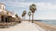 Ruhige spanische Küstenpromenade im Winter mit Palmen und mildem Sonnenlicht